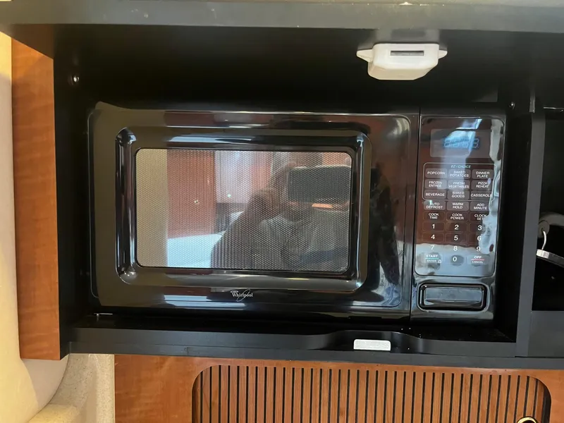Slide: The Image of Microwave in 2002 Sea Ray 320 Sundancer boat interior, featuring wood paneling. - 28