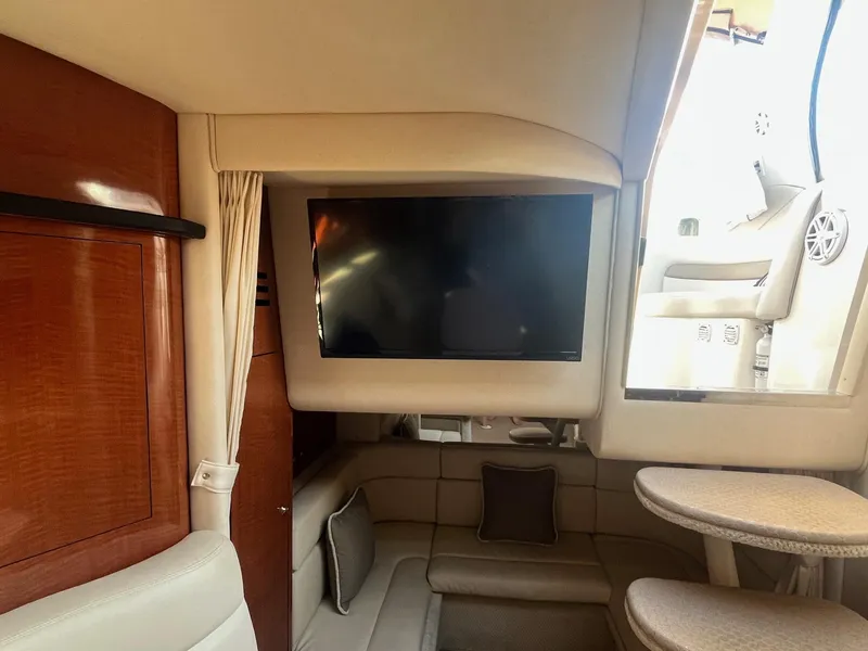 Slide: The Image of Interior of 2002 Sea Ray 320 Sundancer with TV, seating, and wooden cabinetry. - 33
