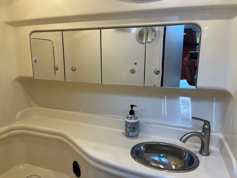 Slide: The Image of Bathroom interior of 2002 Sea Ray 320 Sundancer with sink, mirror, and soap dispenser. - 34
