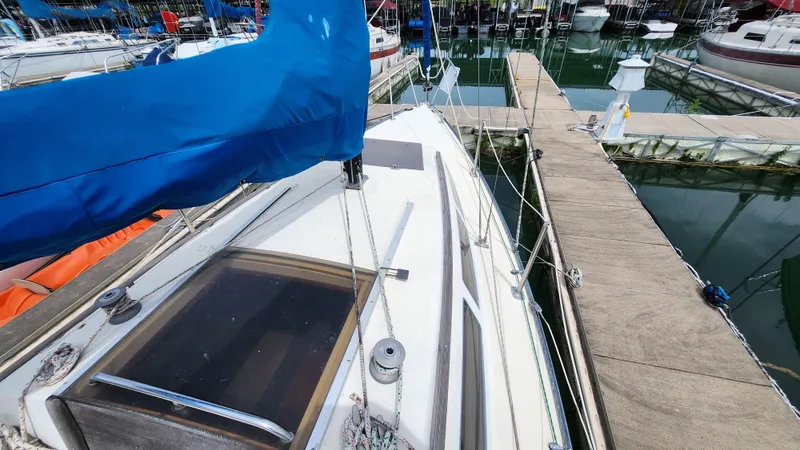 Slide: The Image of Sailboat docked at marina, featuring blue sail cover, S2 7.3 model, 1980. - 1