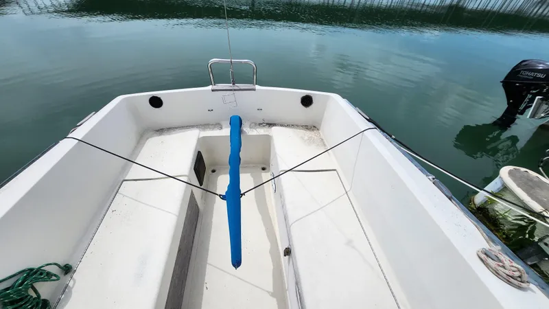 Slide: The Image of 1980 S2 7.3 sailboat cockpit with blue tiller, docked on calm water. - 3