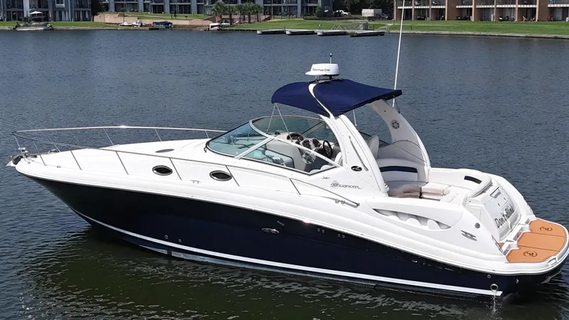 Slide: The Image of 2005 Sea Ray 340 Sundancer boat on calm water, featuring sleek design and blue canopy. - 20