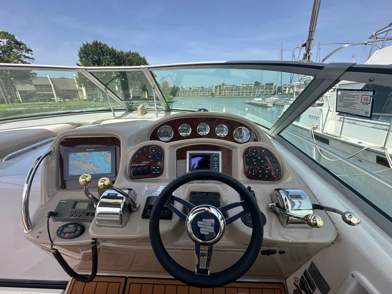 Slide: The Image of 2005 Sea Ray 340 Sundancer helm with navigation controls and marina view. - 30