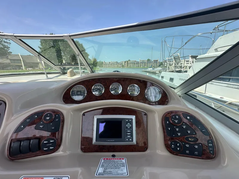 Slide: The Image of 2005 Sea Ray 340 Sundancer dashboard with gauges and controls, marina view in background. - 31