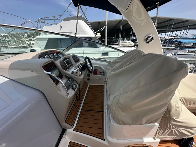 Slide: The Image of 2005 Sea Ray 340 Sundancer helm with covered seats, docked at marina. - 33