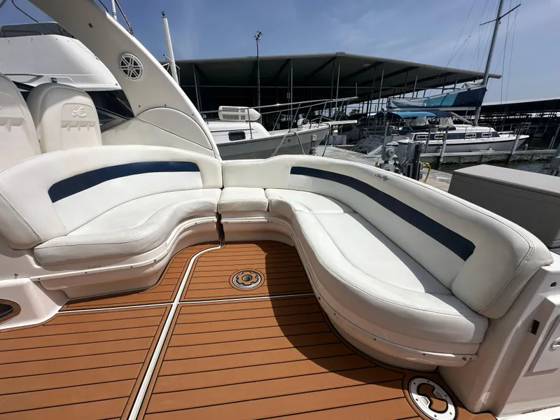 Slide: The Image of 2005 Sea Ray 340 Sundancer boat with white seating and wooden deck at marina. - 39