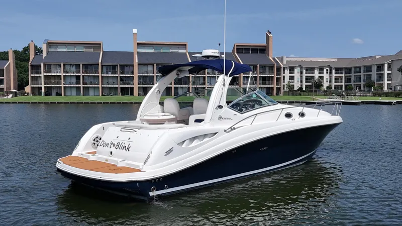 Slide: The Image of 2005 Sea Ray 340 Sundancer boat on water, with modern buildings in the background. - 4