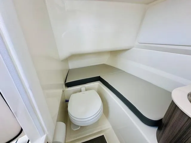 Slide: The Image of 2026 Sea Ray SDX 250 Outboard interior cabin with toilet and seating area. - 20