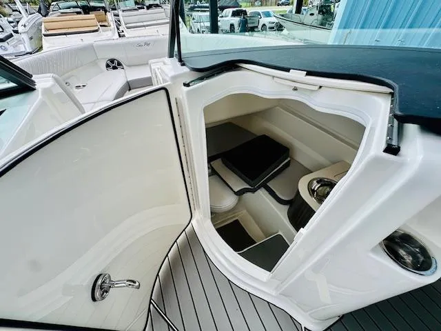 Slide: The Image of 2026 Sea Ray SDX 250 Outboard boat interior with open storage compartment and seating area. - 21