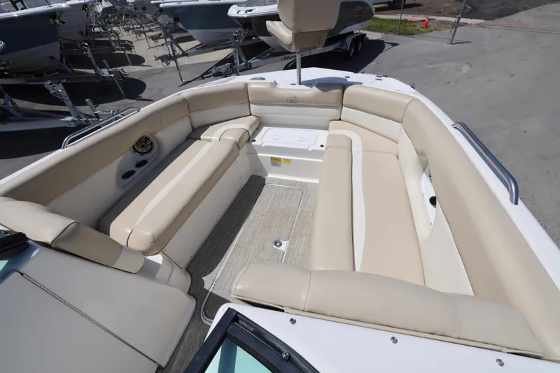 Slide: The Image of 2017 NauticStar 243DC Sport Deck boat with spacious beige seating area. - 10