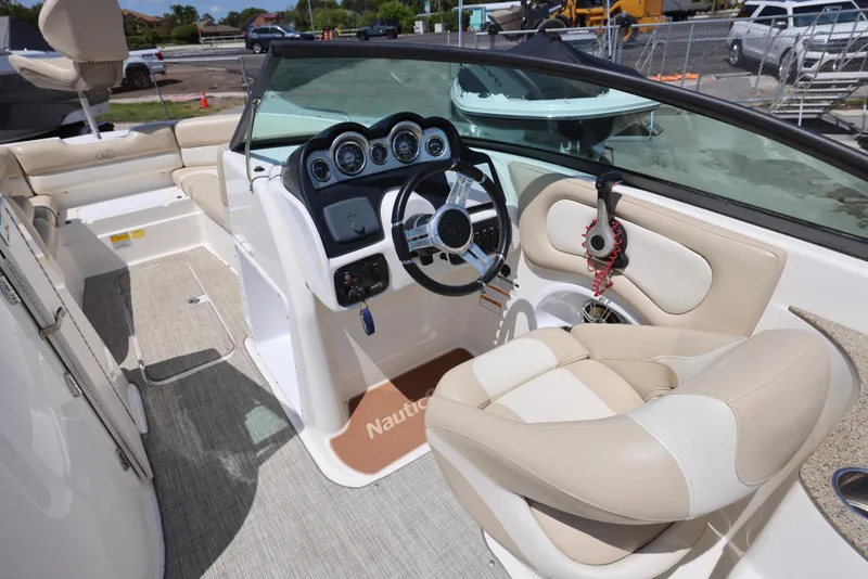 Slide: The Image of 2017 NauticStar 243DC Sport Deck boat interior with steering wheel and beige seating. - 12