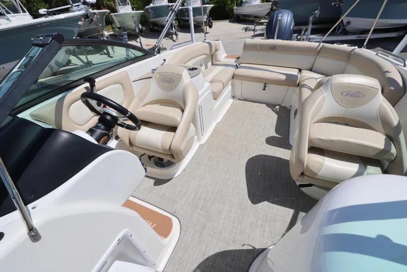 Slide: The Image of 2017 NauticStar 243DC Sport Deck interior with beige seating and steering wheel. - 13