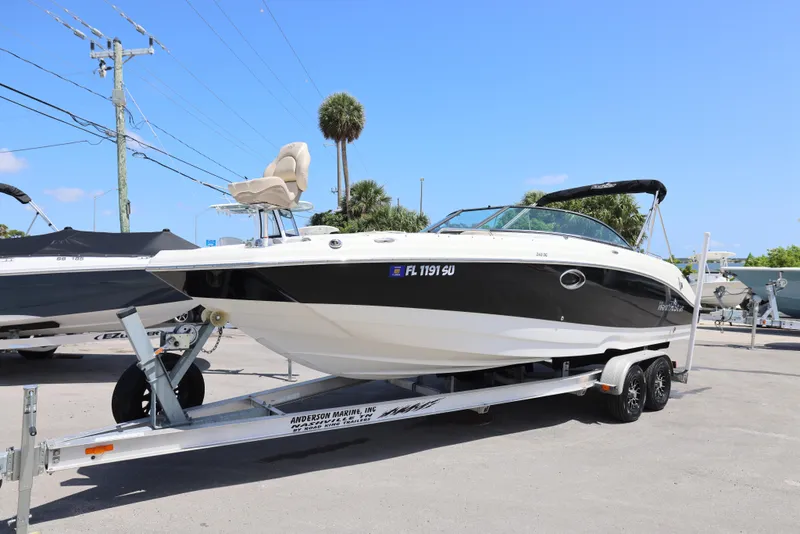 Slide: The Image of 2017 NauticStar 243DC Sport Deck boat on trailer, parked outdoors under clear blue sky. - 15