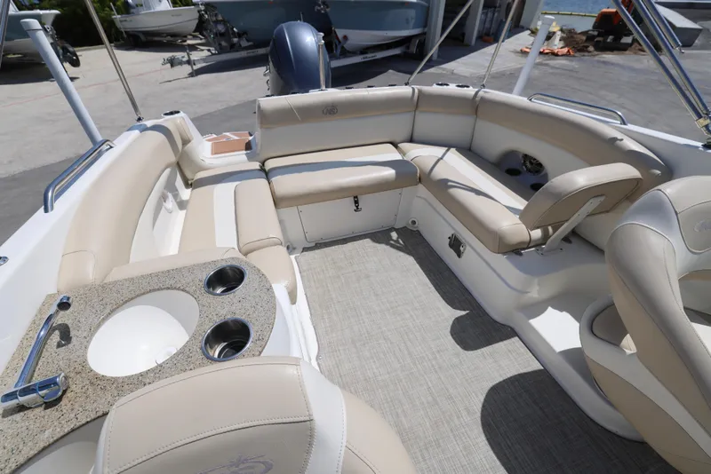 Slide: The Image of 2017 NauticStar 243DC Sport Deck interior with beige seating and built-in sink. - 4