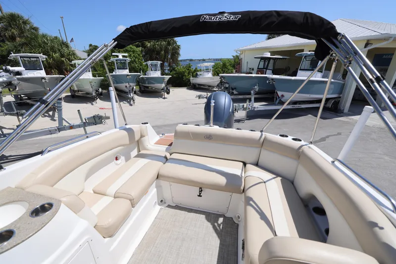 Slide: The Image of 2017 NauticStar 243DC Sport Deck boat interior with beige seating and canopy. - 5