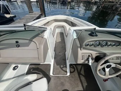 Slide: The Image of 1999 Cobalt 226 boat interior with dashboard and steering wheel, docked by the water. - 13