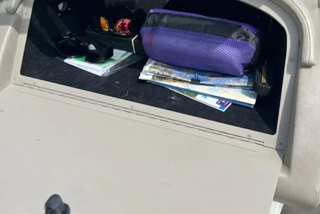 Slide: The Image of Open glove compartment in a 1999 Cobalt 226 boat with maps and a purple pouch. - 17