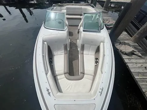 Slide: The Image of 1999 Cobalt 226 boat with white seating, docked on calm water. - 20