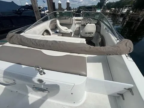 Slide: The Image of 1999 Cobalt 226 boat interior with seating and steering wheel, docked by the water. - 3
