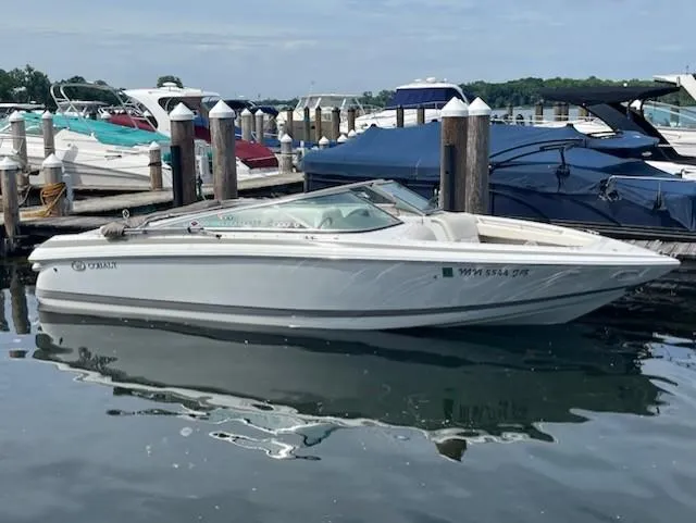 Slide: The Image of 1999 Cobalt 226 boat docked at marina, surrounded by other vessels. - 4