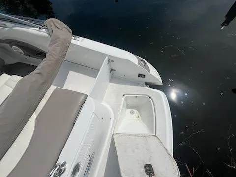 Slide: The Image of 1999 Cobalt 226 boat interior with seating and storage, reflecting sunlight on water. - 5