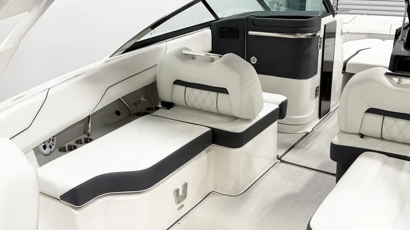 Slide: The Image of 2025 Regal LX4 boat in showroom, front view, navy and white design. - 2