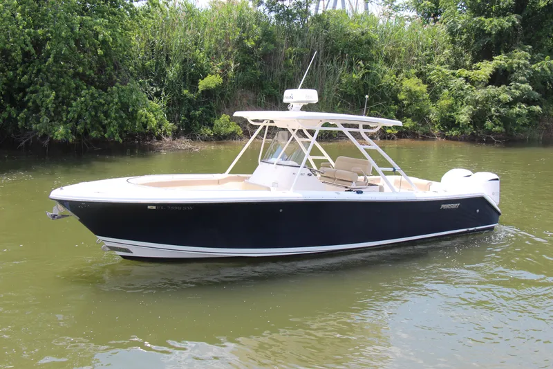 Slide: The Image of 2016 Pursuit S 280 Sport boat on calm water, surrounded by lush greenery. - 10