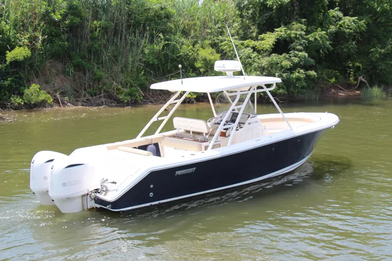 Slide: The Image of 2016 Pursuit S 280 Sport boat on calm water, surrounded by lush greenery. - 2