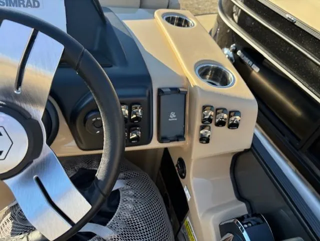 Slide: The Image of 2025 Harris Sunliner 230 boat dashboard with steering wheel and control panel. - 10