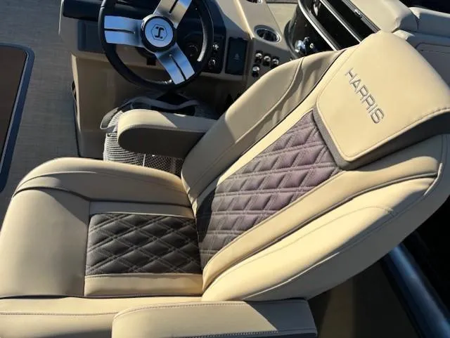 Slide: The Image of 2025 Harris Sunliner 230 boat interior with luxurious beige and black quilted seating. - 11
