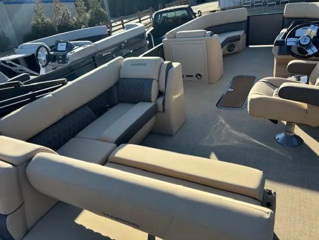 Slide: The Image of 2025 Harris Sunliner 230 boat interior with beige seating and modern dashboard. - 12