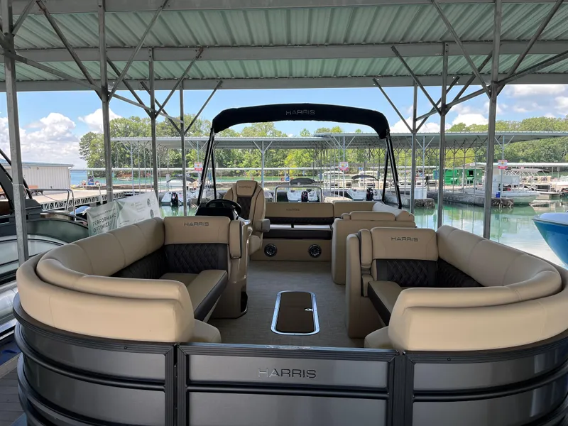 Slide: The Image of 2025 Harris Sunliner 230 pontoon boat with luxurious seating at a marina dock. - 4