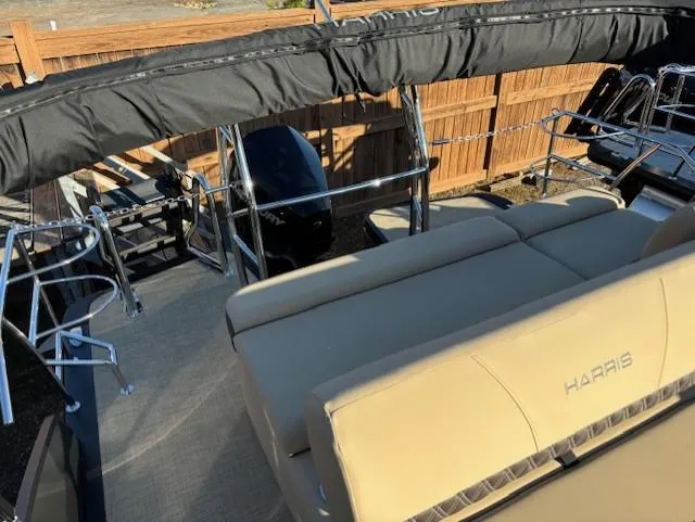 Slide: The Image of 2025 Harris Sunliner 230 pontoon boat with beige seating and black canopy. - 7