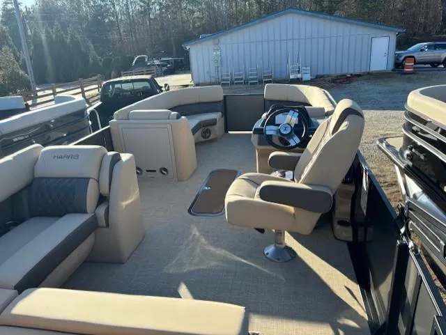 Slide: The Image of 2025 Harris Sunliner 230 boat interior with beige seating and steering console. - 8