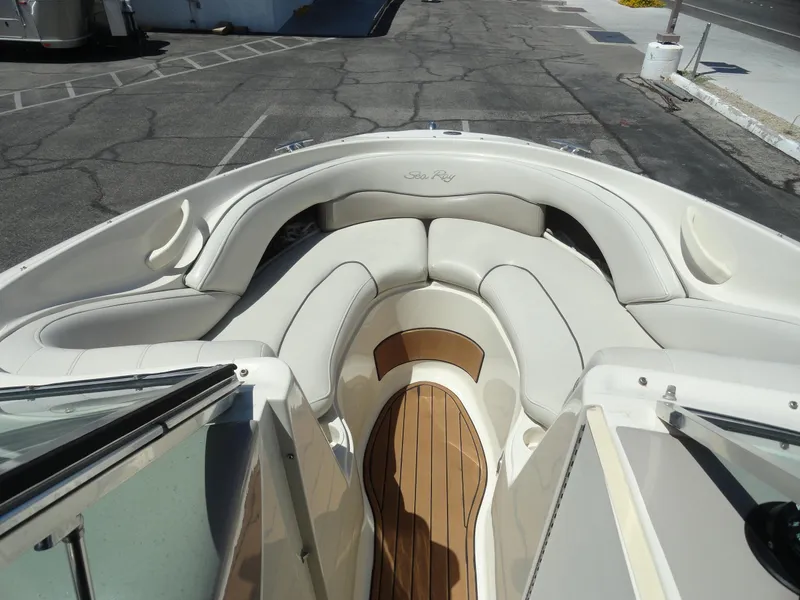 Slide: The Image of 2002 Sea Ray 220 Bow Rider interior with white seating and wooden flooring. - 14
