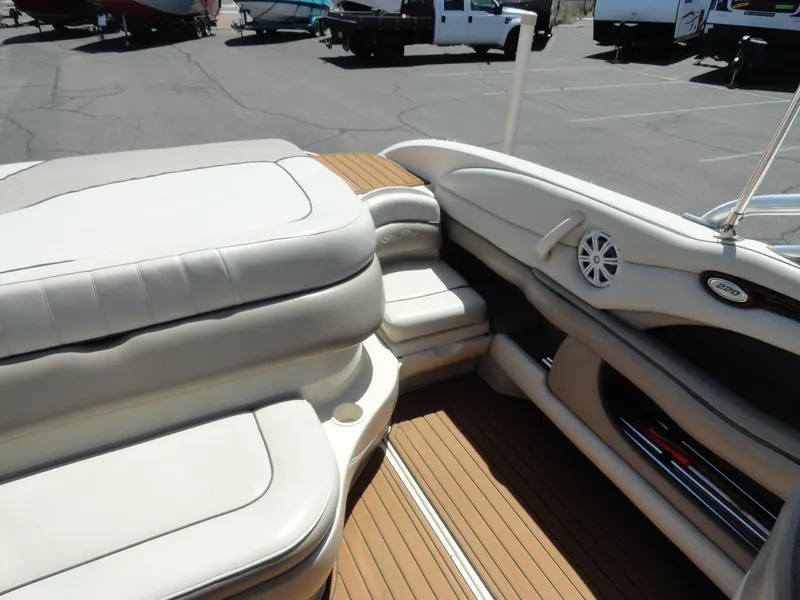 Slide: The Image of 2002 Sea Ray 220 Bow Rider interior with beige seating and wood-style flooring. - 16
