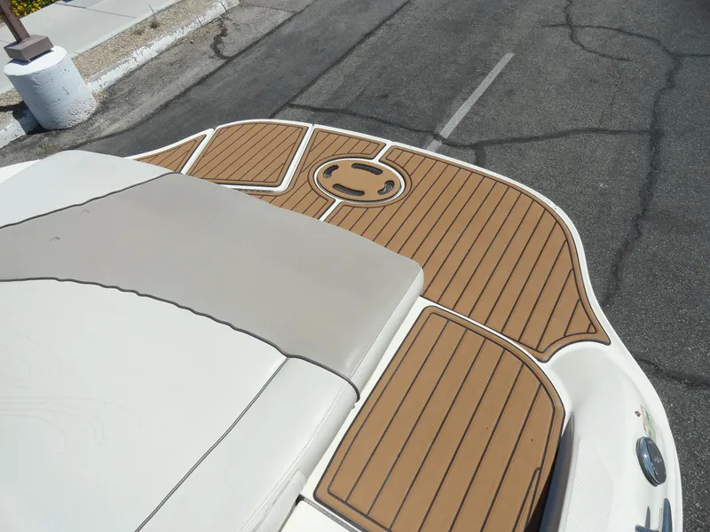 Slide: The Image of 2002 Sea Ray 220 Bow Rider boat with teak-style deck on a paved surface. - 17