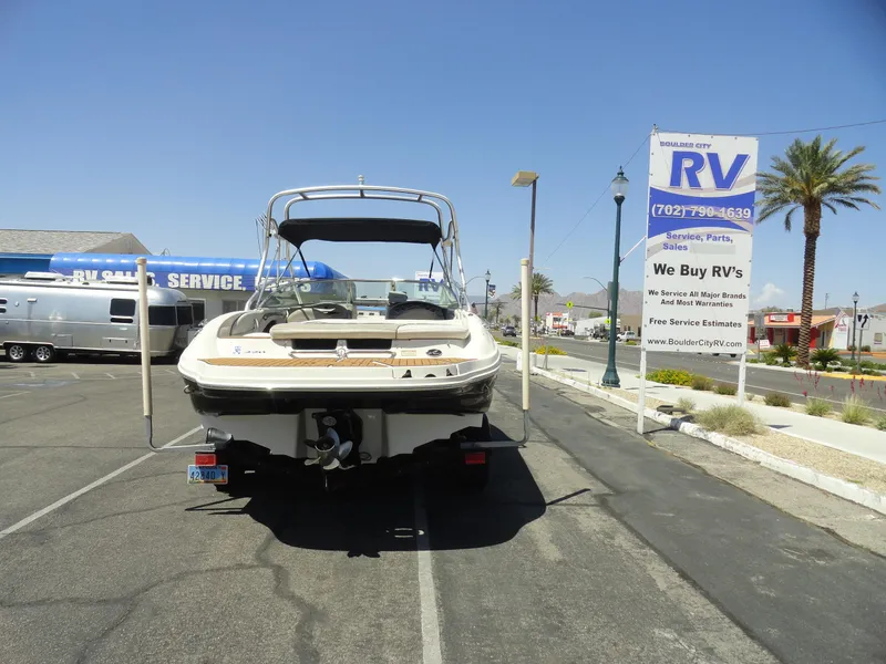 Slide: The Image of 2002 Sea Ray 220 Bow Rider parked at RV sales lot under clear blue sky. - 20