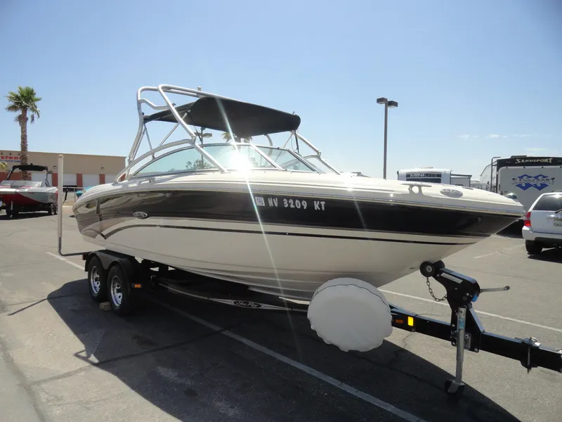 Slide: The Image of 2002 Sea Ray 220 Bow Rider boat on trailer in sunny parking lot. - 4
