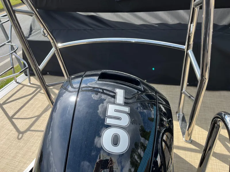Slide: The Image of Outboard motor on 2025 Harris Cruiser 230 pontoon boat, featuring chrome railings. - 4