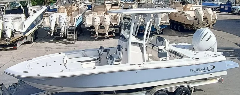 Slide: The Image of 2025 Robalo 246 Cayman boat with Yamaha engine on trailer in marina. - 0