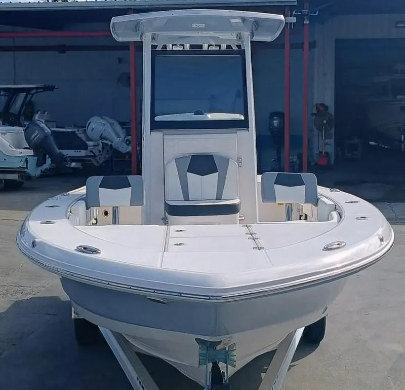 Slide: The Image of 2025 Robalo 246 Cayman boat, front view, in a marina setting. - 2