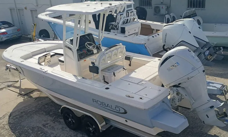 Slide: The Image of 2025 Robalo 246 Cayman boat with dual outboard engines, parked on a trailer. - 4