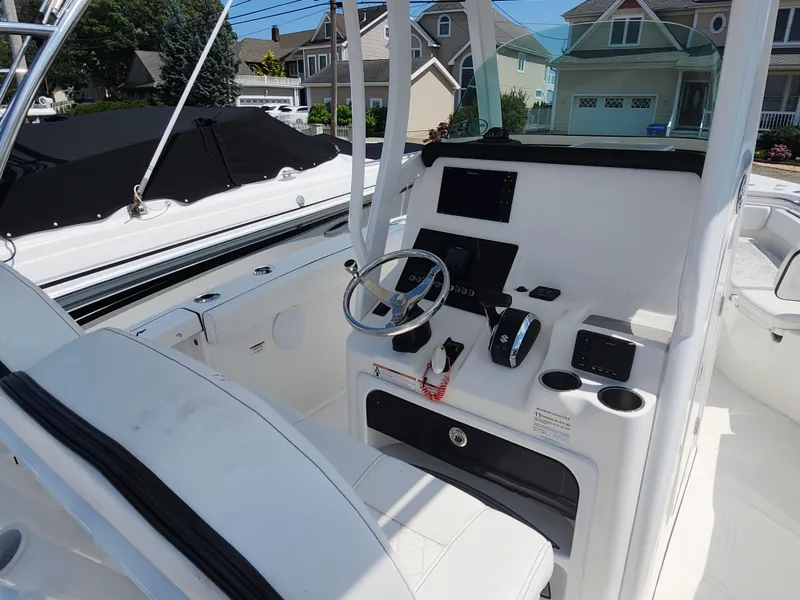Slide: The Image of 2022 Sea Pro 239 Center Console boat interior with steering wheel and control panel. - 3