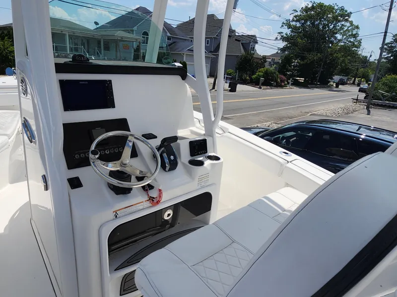 Slide: The Image of 2022 Sea Pro 239 Center Console boat interior with steering wheel and control panel. - 4