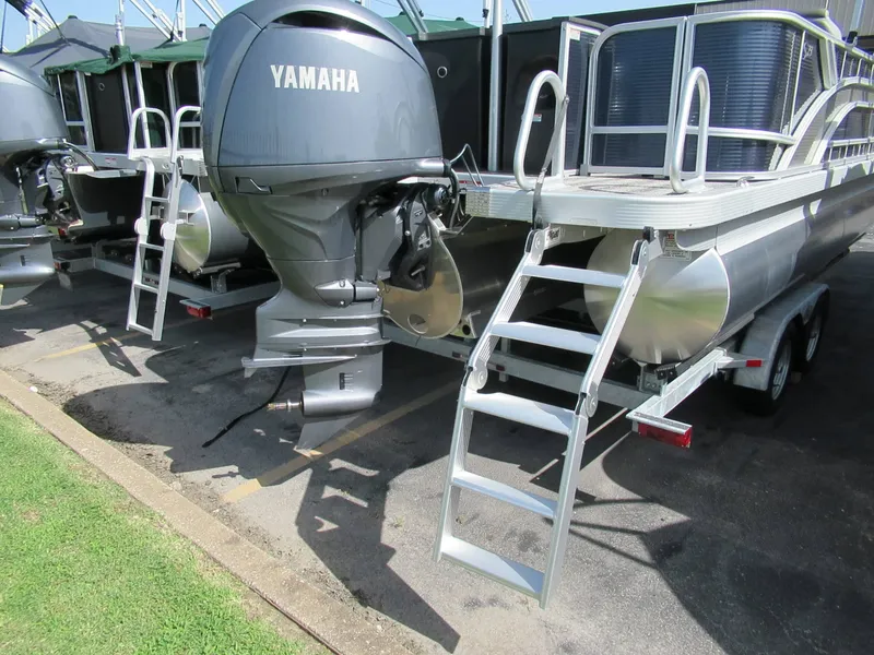 Slide: The Image of A Bennington 23 SF pontoon boat with Yamaha outboard motor, parked on a trailer. - 9