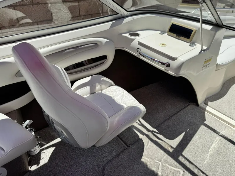 Slide: The Image of Interior of a 2006 Stingray 195 LR boat with white seating and dashboard. - 10