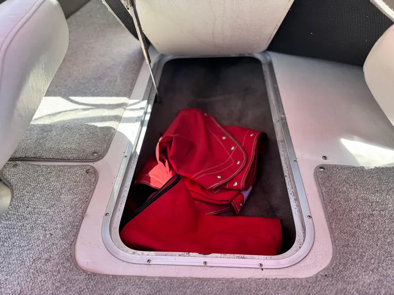 Slide: The Image of Storage compartment in 2006 Stingray 195 LR boat with red cover inside. - 16