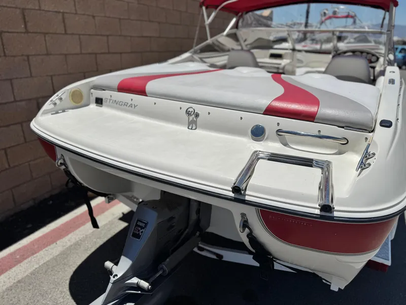 Slide: The Image of 2006 Stingray 195 LR boat with red and white upholstery, parked on a trailer. - 6
