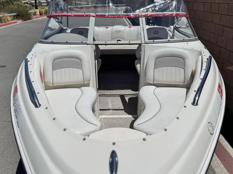 Slide: The Image of 2006 Stingray 195 LR boat with white interior and windshield, parked on a sunny day. - 8